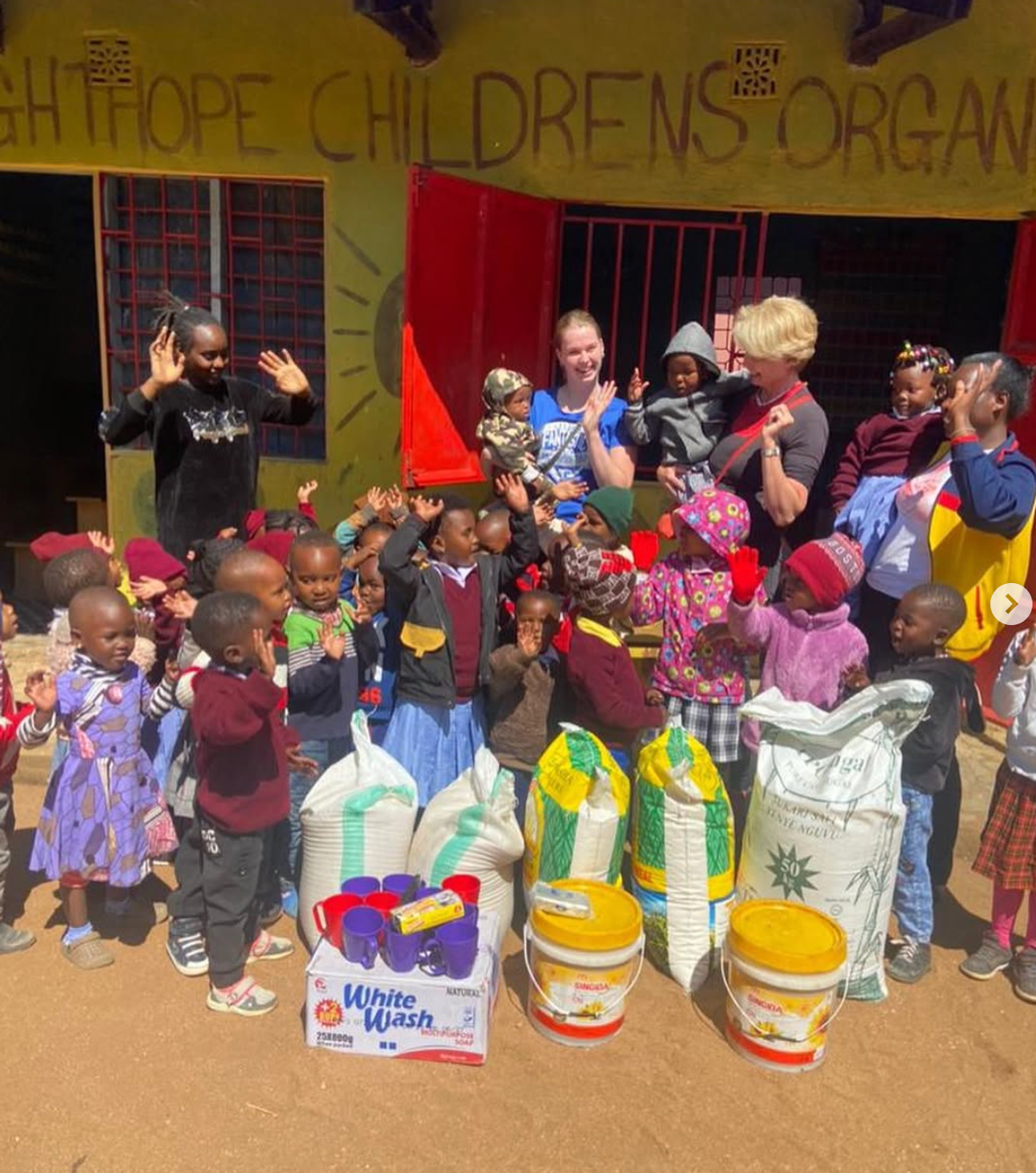 Volunteers with children and supplies at Bright Hope Children's Organisation