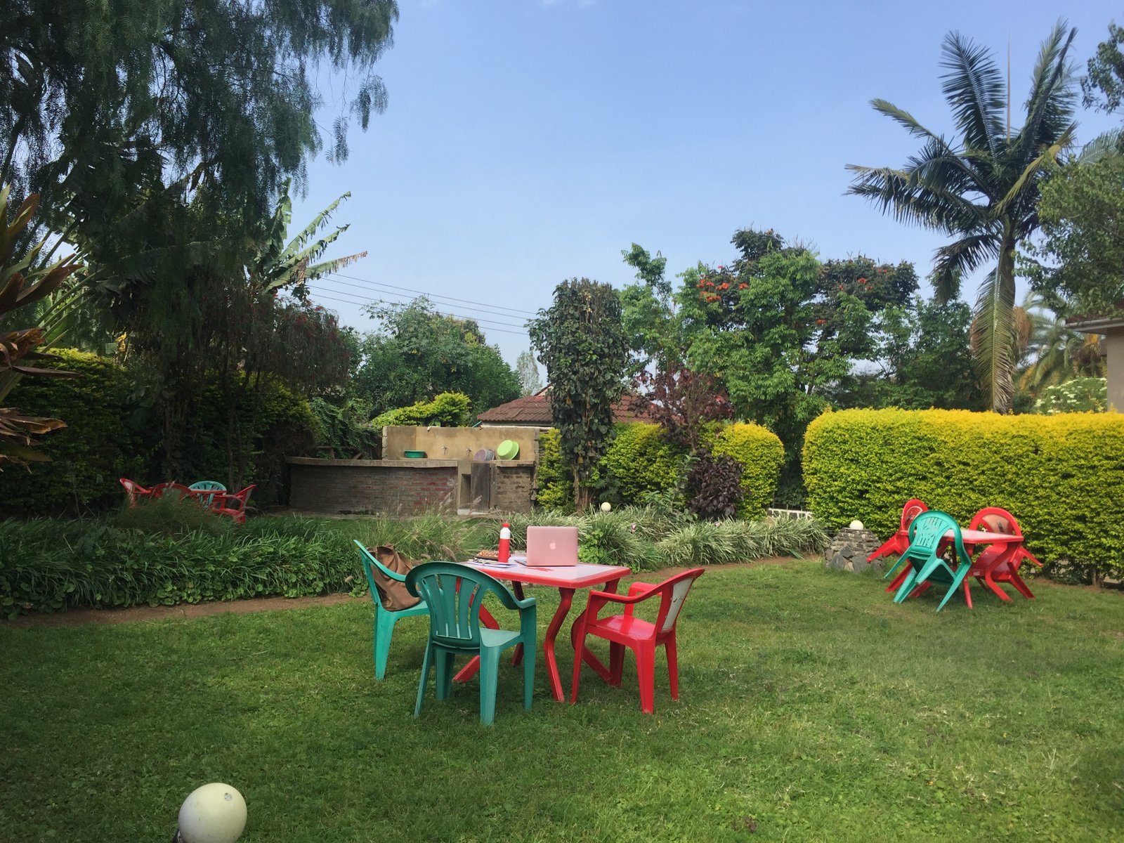 Garden seating area with colourful chairs at the VIT Arusha House