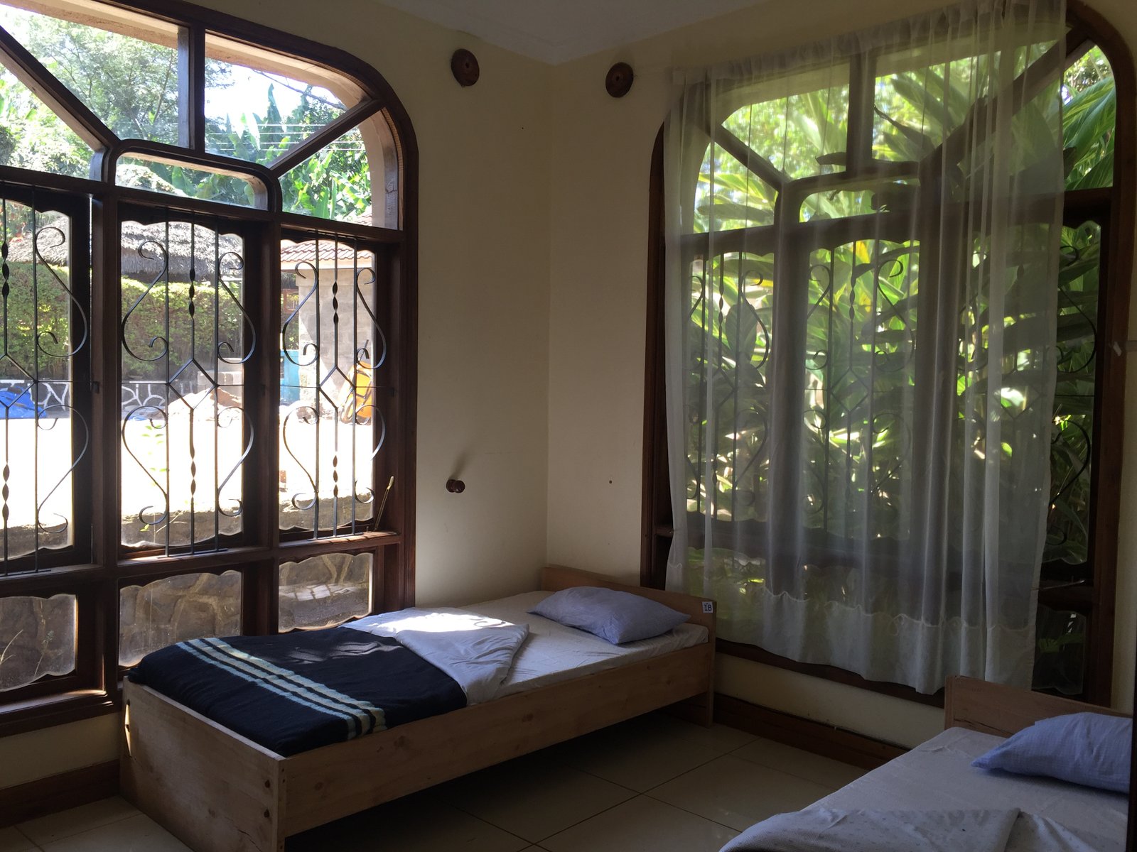 Bright bedroom with garden views at the Arusha lodge
